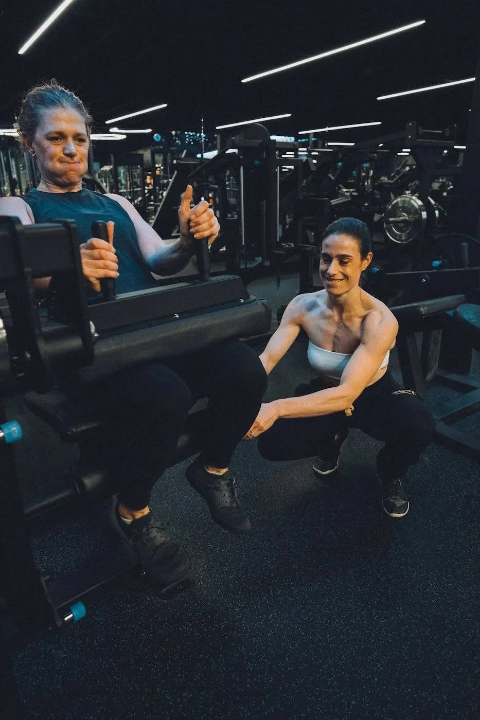 Erika coaching a client on seated leg curls at The Lab Gym in San Ramon